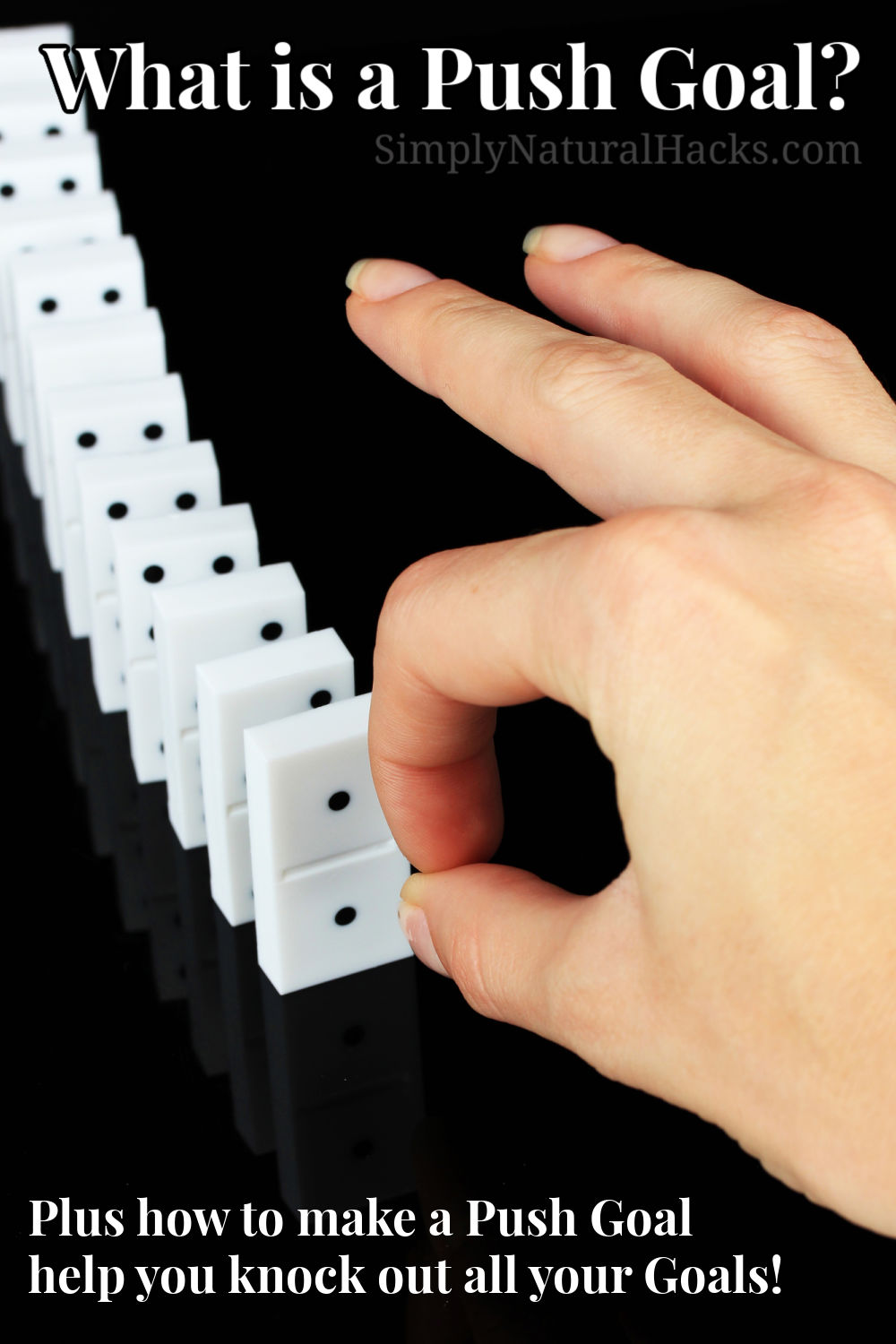 hand pushing over dominoes
